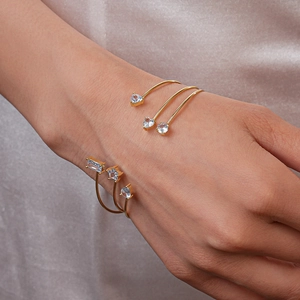 Détail du bracelet doré multicouche avec zircons bleu clair sur fond de soie douce