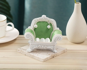 Detailed view of mini sofa jewelry stand with green velvet and white carved relief