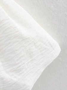 Dettaglio macro della trama del tessuto plissettato bianco con tocco di cotone