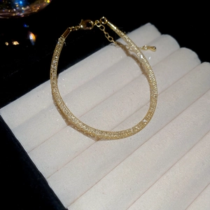 Vue détaillée d'un bracelet doré en zircons avec un fermoir mousqueton réglable