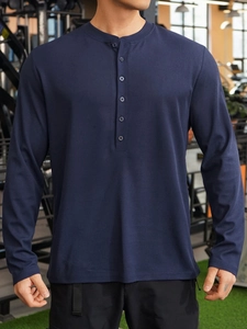Detail of navy blue ribbed gym polo showing long sleeves and Henley button neckline