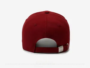 Detail of adjustable metal buckle and canvas texture on wine red baseball cap back