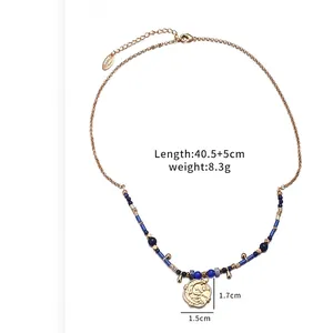Gold plated celestial pendant necklace featuring sun moon relief and blue bead detail