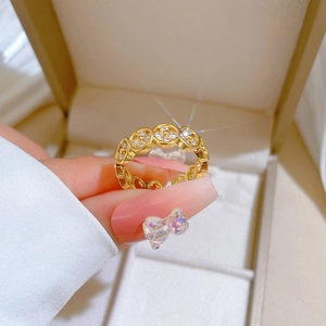 Detailed view of gold clover pattern ring with sparkling stones on hand