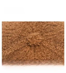 Close-up of brown faux shearling fabric texture and stitching detail on baseball cap
