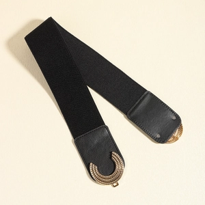 Close-up of a wide elastic belt featuring a layered gold metal buckle and black faux leather