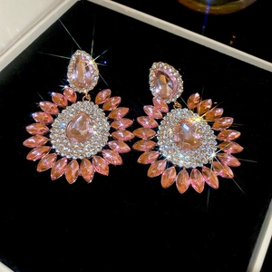 Détail de boucles d'oreilles vintage en cristal rose avec glands en diamant et or