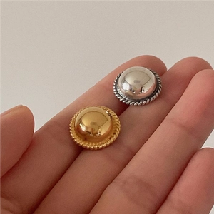 Close-up of vintage 925 silver stud earrings with smooth mirror finish and rope texture
