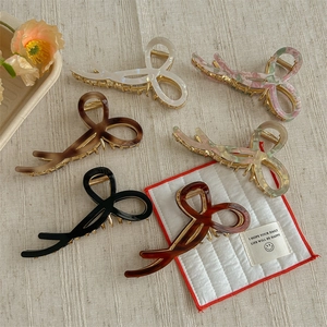 Set of six colorful acetate bow-shaped hair claws in various marble and tortoiseshell patterns