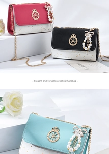 Detail of crossbody bag with saffiano texture, metal chain, and pearl bow pendant decoration