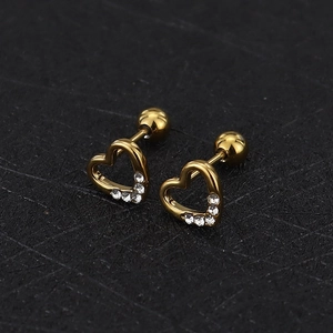 Macro detail of gold-toned heart ear studs with white rhinestones and screw-back closures
