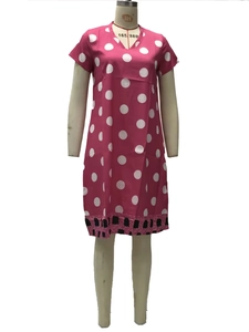Detail of pink polka dot dress showing V-neck design and artistic printed hem texture