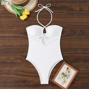 Détail à plat du maillot de bain blanc dos nu avec découpes sur fond en bois d'été