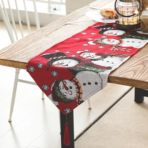 Christmas table runner with knitted snowman patterns, snowflakes and red decorative tassels