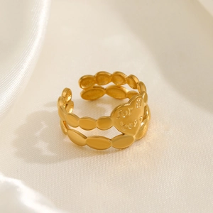 Minimalist gold heart ring with beaded edge and engraved details on silk background