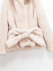 Detailed view of plush faux fur texture with elegant oversized bow waist tie in pink