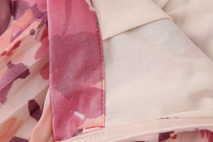Vista macro del tessuto a stampa floreale rosa con cerniera invisibile e fodera di qualità