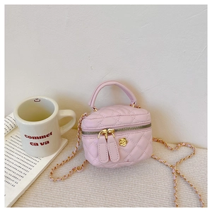 Detail of pink quilted girl's crossbody bag with gold chain strap and flower hardware