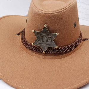 Nahaufnahme eines bronzenen SHERIFF-Sternabzeichens auf einem braunen Cowboyhut
