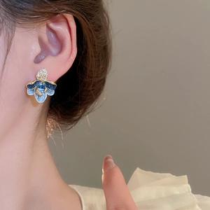 Detail von Vintage Blumen-Ohrring mit blauem Emaille und funkelnden Kristall-Akzenten