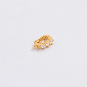 Macro shot of S925 sterling silver gold clasp with three clear gemstones for pendants