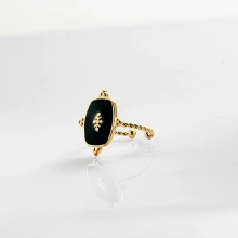 Detailed shot of retro gold rope ring with black enamel and gold center motif
