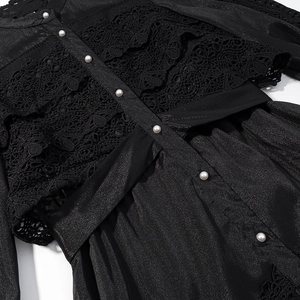 Detail of black dress with sheer lace stitching and elegant white pearl buttons