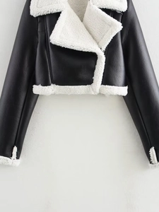 Close-up of black leather biker jacket featuring soft white faux fur collar and texture