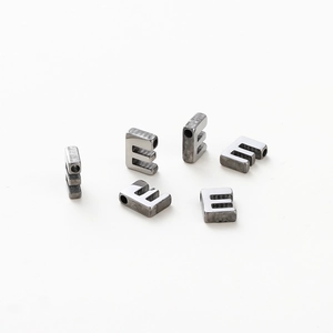 Macro view of six silver-toned metal letter E beads for DIY jewelry making accessories
