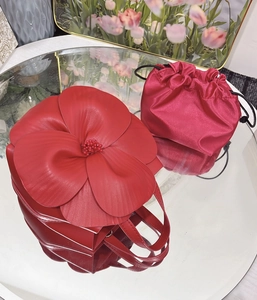 Detail of red 3D floral tote bag with leather petals and matching silk drawstring pouch