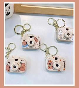 Vue détaillée de quatre adorables porte-clés Capybara en forme d'appareil photo.