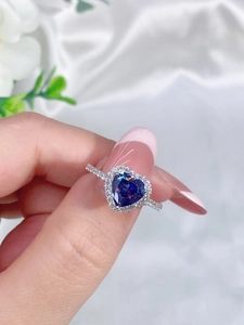 Detailed view of sterling silver halo ring featuring a blue heart-shaped gemstone