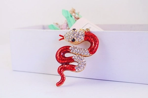 Detail shot of a luxury snake keychain with red enamel and sparkling white rhinestones
