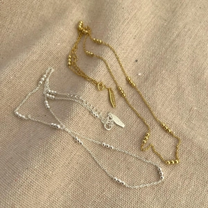 Detailed macro view of 925 sterling silver beaded chain necklaces in gold and silver