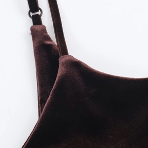 Macro detail of velvet dress showing thin shoulder straps and metal adjustment ring