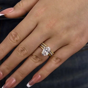 Detailansicht eines 3-teiligen Goldring-Sets mit ovalem Edelstein und Pavé-Diamanten am Finger
