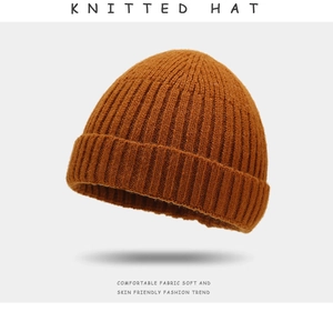 Close-up of caramel knitted hat showing thick textured fabric and ribbed details