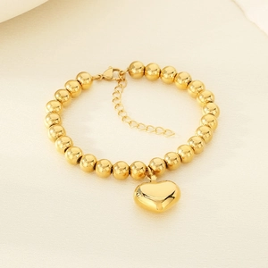 Detail of 18K gold plated beaded bracelet with heart charm and lobster clasp closure