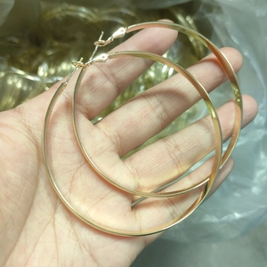 Handheld 5mm wide gold hoop earrings with polished finish and sterling silver needles