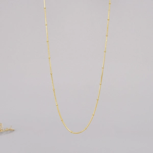 Elegant 18K gold satellite chain necklace with fine beads on a minimalist steel base