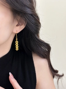 Close-up of golden multi-circle tassel earrings worn by a model in neo-Chinese style