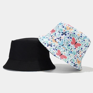 Detail of reversible sun hat showing solid black side and floral butterfly pattern fabric