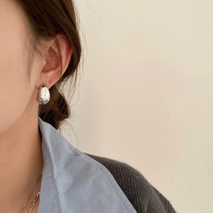 Nahaufnahme von minimalistischem Silber-Tropfenohrring mit Hochglanz-Finish am Modell