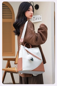 Detail view of the large capacity waterproof backpack on a model in a cozy cafe setting