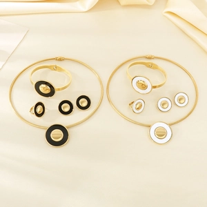 Detail of four-piece gold plated jewelry set featuring black and white enamel finishes
