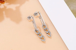Macro shot of silver chain drop earrings in polished titanium steel for a modern look