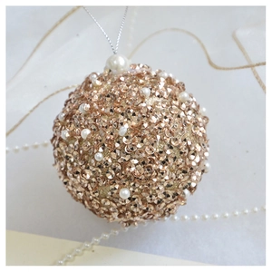 Detail of champagne gold Christmas ball with sequins and elegant white pearls