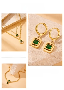 Détail d'une pierre d'émeraude carrée sur un collier et un bracelet dorés