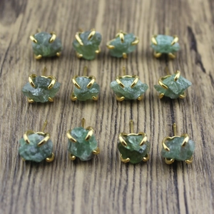 Detail view of 12 pieces green raw stone stud earrings with gold claw settings