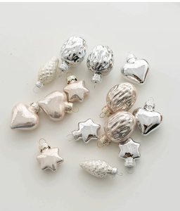 Flat lay of champagne and silver glass Christmas ornaments in heart and star shapes